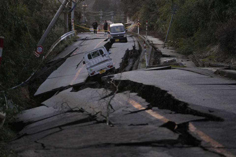 Bystanders look at damages somewhere near Noto town in the Noto peninsula facing the Sea of Japan, northwest of Tokyo, Tuesday, Jan. 2, 2024, following Monday’s deadly earthquake. A series of powerful earthquakes that hit western Japan have damaged thousands of buildings, vehicles and boats. Officials warned that more quakes could lie ahead. | Hiro Komae, Associated Press