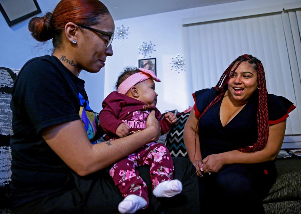 Kristy Bassel, left, holds 3-month-old Cali while her doula Evelyn Comer, right, looks on at Bassel’s home in Milwaukee on Nov. 22.