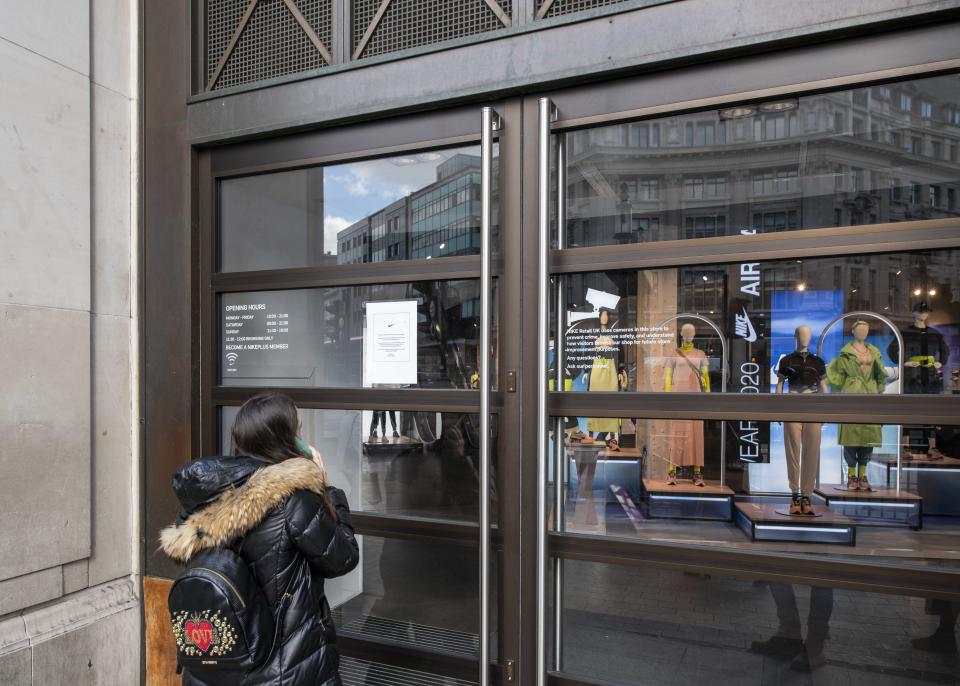 A shopper reads a closure sign on the doors of Niketown in Oxford Circus which closed due to the Coronavirus, Oxford Road, London.  Picture date: Monday 16th March 2020.  Photo credit should read:  David Jensen/ EMPICS Entertainment