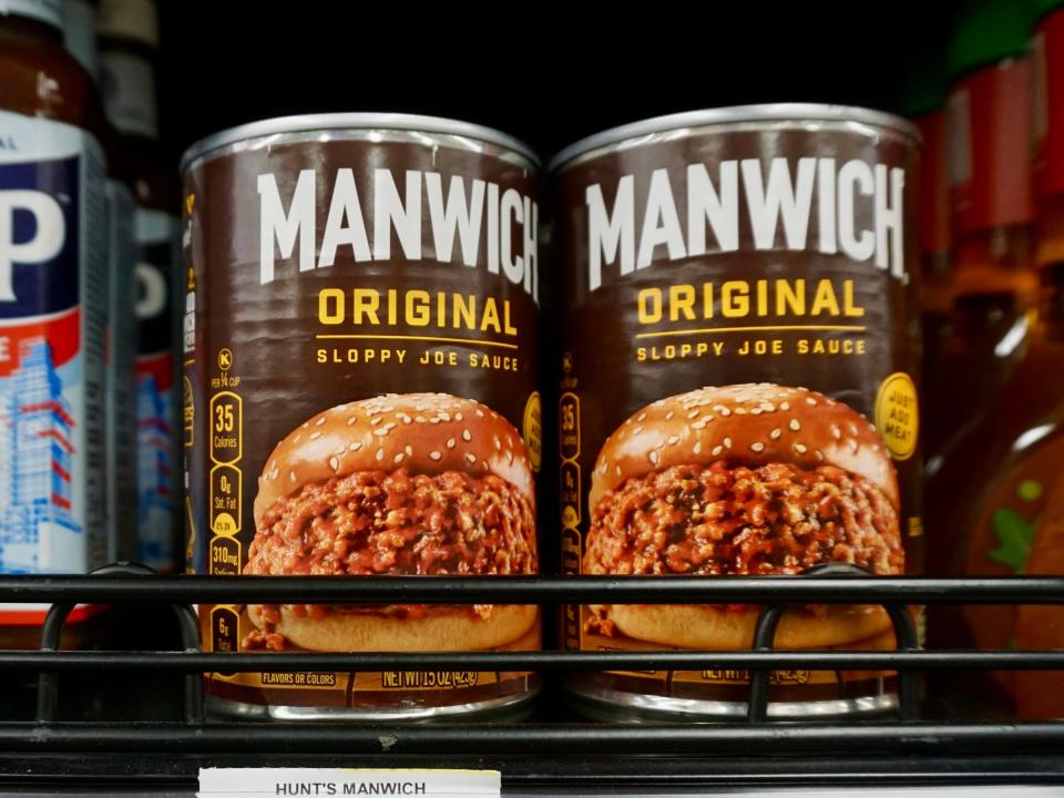 two manwich cans on shelves at thai grocery store