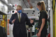 Britain's Prime Minister Boris Johnson, wearing a face mask, talks with a paramedic as they stand inside the back of an ambulance during a visit to the headquarters of the London Ambulance Service NHS Trust in London, Monday July 13, 2020. (Ben Stansall/Pool via AP)