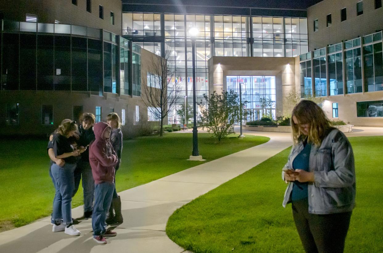 Evacuated students bide their time as Peoria police officers search the Business and Engineering Convergence Center during a lockdown Tuesday, April 25, 2023, on the Bradley University campus.