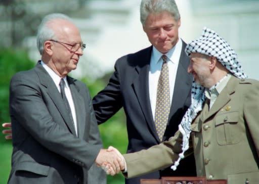 US president Bill Clinton stands between PLO leader Yasser Arafat and Israeli Prime Minister Yitzahk Rabin as they shake hands on September 13, 1993 at the White House after signing the Oslo Accords