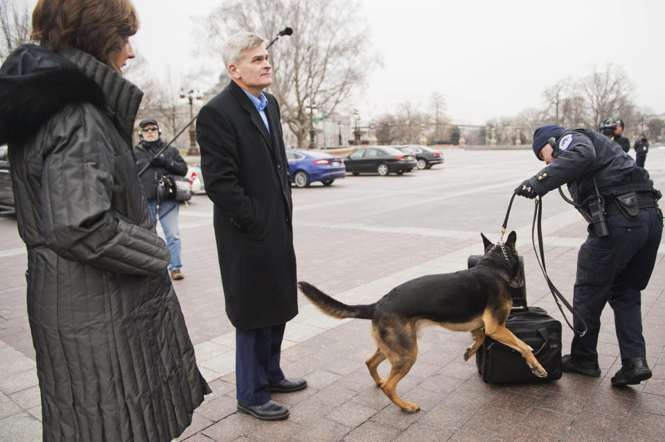 Sen. Bill Cassidy (R-La.) and his wife, Laura, have their luggage inspected by a police dog before boarding a bus that will take Republican senators to a retreat in Hershey, Pa., January 14, 2015.