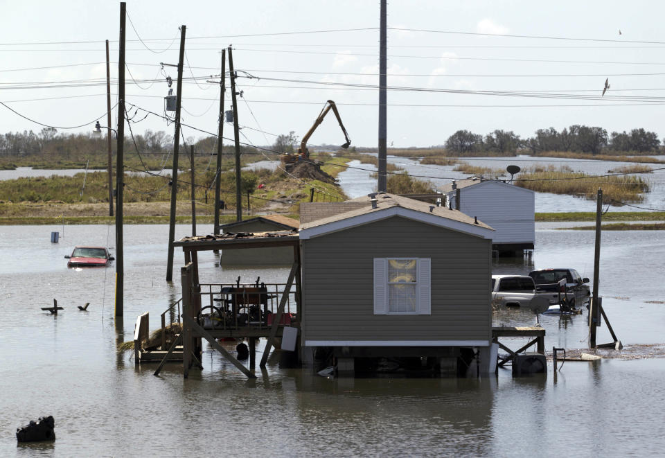 Trucks are flooded in receding flood waters from Hurricane Isaac along Louisiana Hwy 23 near West Point a La Hache, La., in Plaquemines Parish Monday, Sept. 3, 2012. (AP Photo/Matthew Hinton)