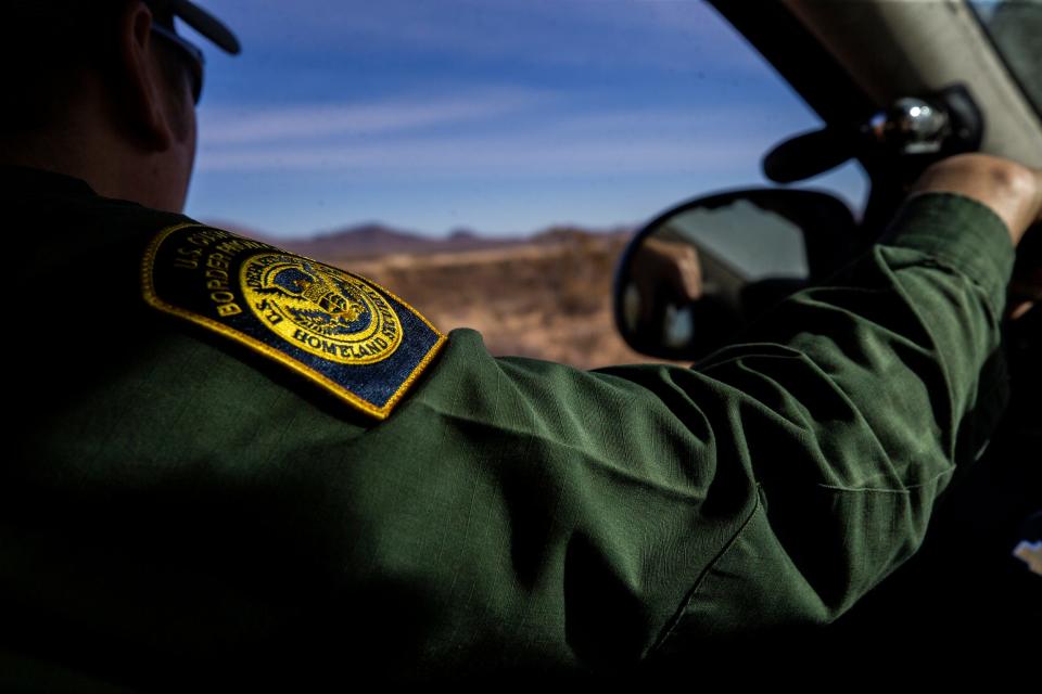 A U.S. Border Patrol officer scans a rural area in New Mexico for tracks on the desert landscape in early January 2022. 