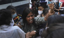 A woman reacts as police detain activists protesting against gang rape and killing of a woman in India's northern state of Uttar Pradesh during a protest in New Delhi, India, Thursday, Oct. 1, 2020. The gang rape and killing of the woman from the lowest rung of India's caste system has sparked outrage across the country with several politicians and activists demanding justice and protesters rallying on the streets. (AP Photo/Manish Swarup)