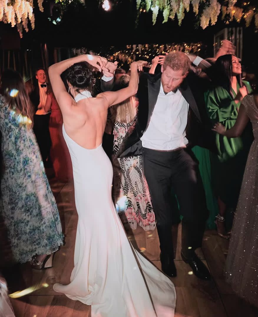 meghan markle and prince harry dance at their wedding, with meghan wearing a backless dress