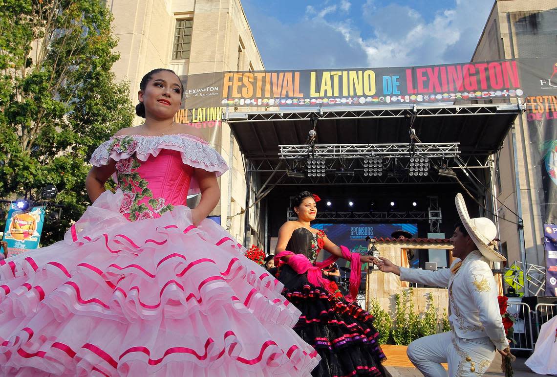 A dancer looks on as Pamela Hernandez and Francisco Espinosa of Arte Latino perform the Quinceanera dance at Festival Latino de Lexington at Robert F. Stephens Courthouse Plaza in Lexington, Ky., Saturday, September 16, 2017.