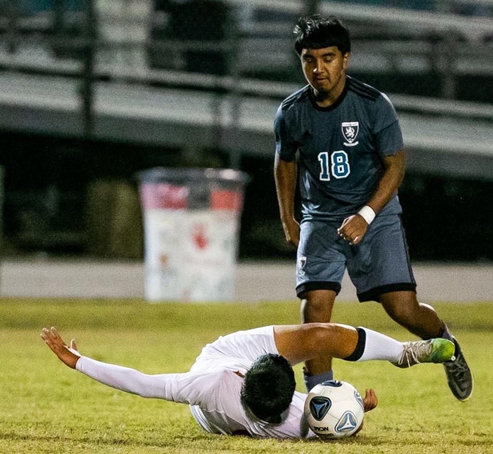 North Marion #11 Robin Dubon falls to ground while going after the ball in the second half while being defended by West Port #18 Gustavo Maldonado. West Port High School defeated North Marion 6-1, Thursday night in a boys soccer matchup at West Port High School in Ocala, FL.  [Doug Engle/Ocala Star-Banner]2021