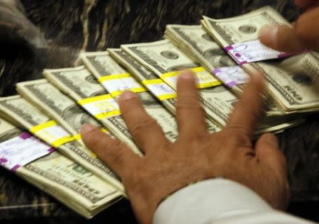 U.S. dollars are counted out by a banker at a bank in Westminster, Colorado November 3, 2009. REUTERS/Rick Wilking