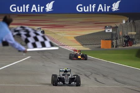 Formula One - Bahrain F1 Grand Prix - Sakhir, Bahrain - 03/04/16 - Mercedes F1 driver Nico Rosberg of Germany crosses the finish line ahead of Ferrari F1 driver Kimi Raikkonen of Finland and Mercedes F1 driver Lewis Hamilton of Britain. REUTERS/Andrej Isakovic/Pool