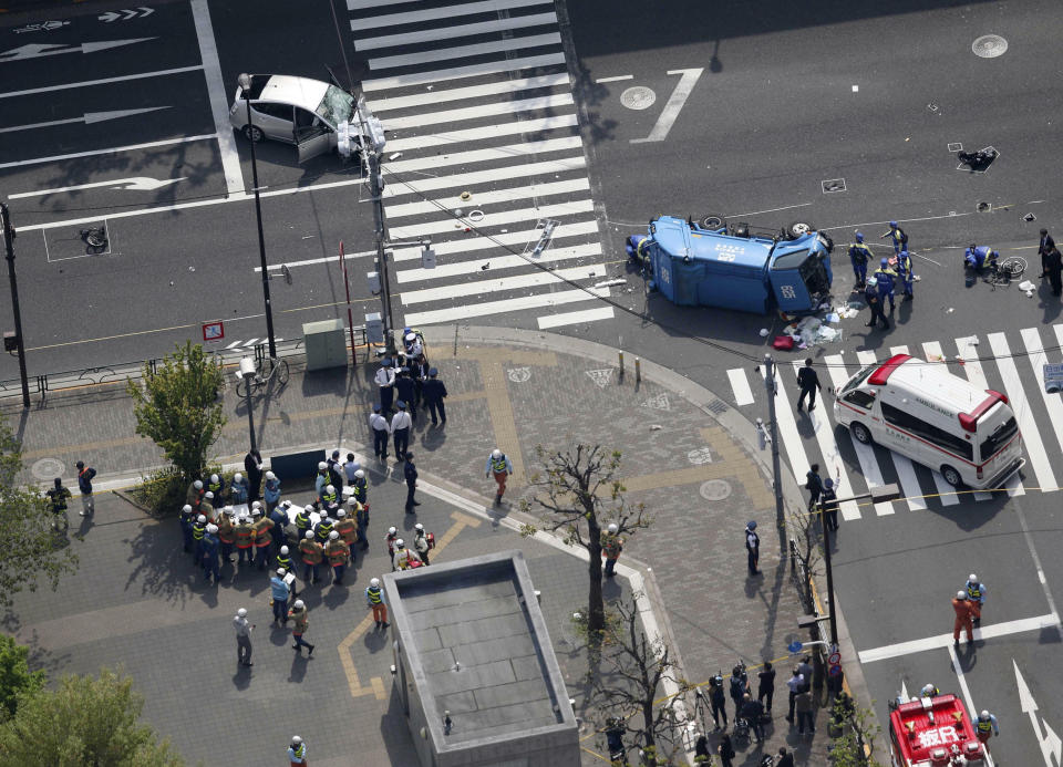 Police officers inspect the scene of a car accident in Tokyo Friday, April 19, 2019. A car, left top, driven by an 87-year-old man crashed into a garbage truck, in blue, on a Tokyo street Friday, killing a woman and a girl who were on a bicycle, according to police. (Shinji Kita/Kyodo News via AP) (Yuta Omori/Kyodo News via AP)