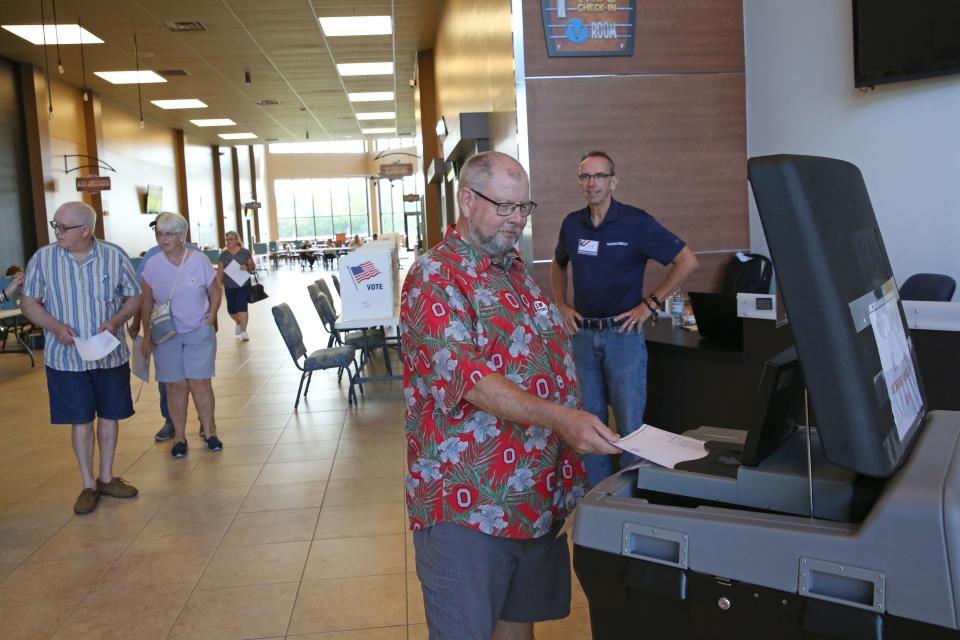 Mark Blakey of Rice Township casts his ballot, as Polling Location Site Administrator Lee Shaffer looks on. According to Shaffer, voting at Victory Church on Oak Harbor Road, has been very busy and much busier than the last primary election this past spring.