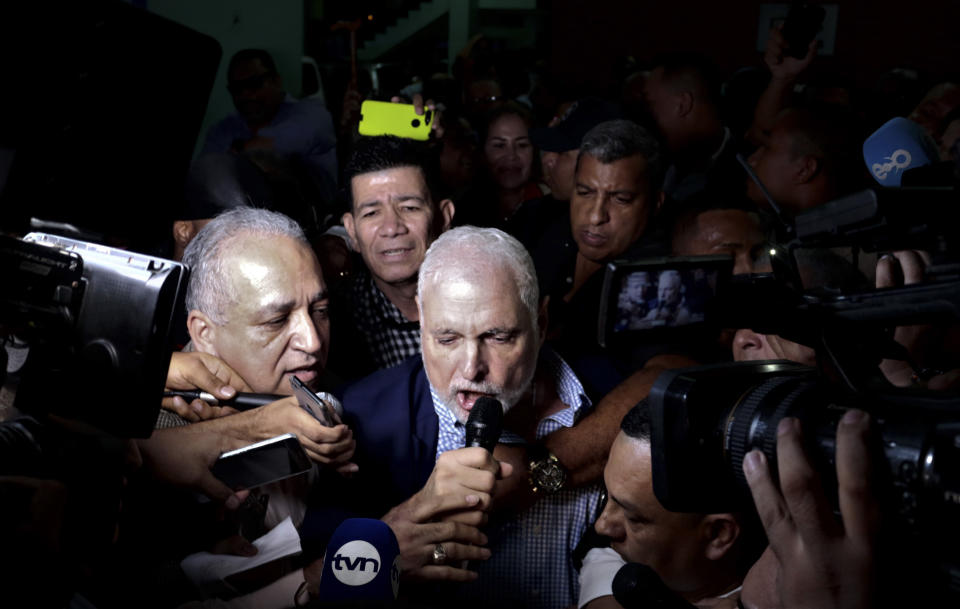 Panama's former President Ricardo Martinelli talks to reporters as he leaves a courthouse after he was found not guilty of political espionage, in Panama City, Friday, Aug. 9, 2019. A Panamanian court has cleared Martinelli of political espionage during his administration and ordered him released from house arrest, though the judges are continuing an order barring him from leaving the country. (AP Photo/Eric Batista)