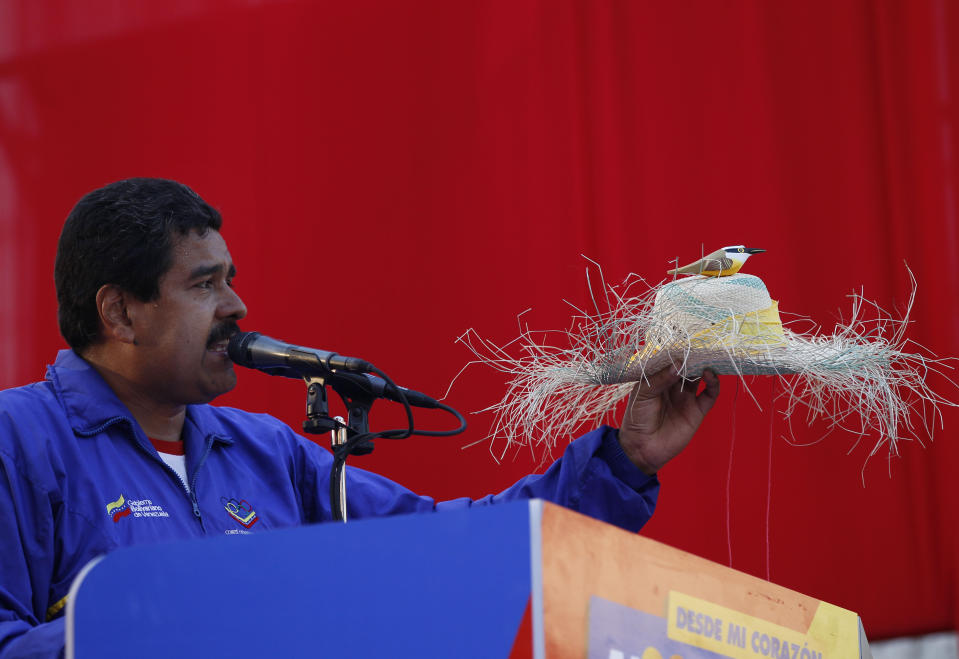 ARCHIVO - El aspirante a presidente de Venezuela, Nicolás Maduro, muestra un sombrero de granjero con una figura de un pájaro en un acto de campaña para las elecciones presidenciales en Catia La Mar, Venezuela, el 9 de abril de 2013. Maduro aseguró en un acto de campaña de entonces que el fallecido presidente Hugo Chávez se le había aparecido como un pajarito y le dio su bendición. (AP Foto/Ariana Cubillos, Archivo)