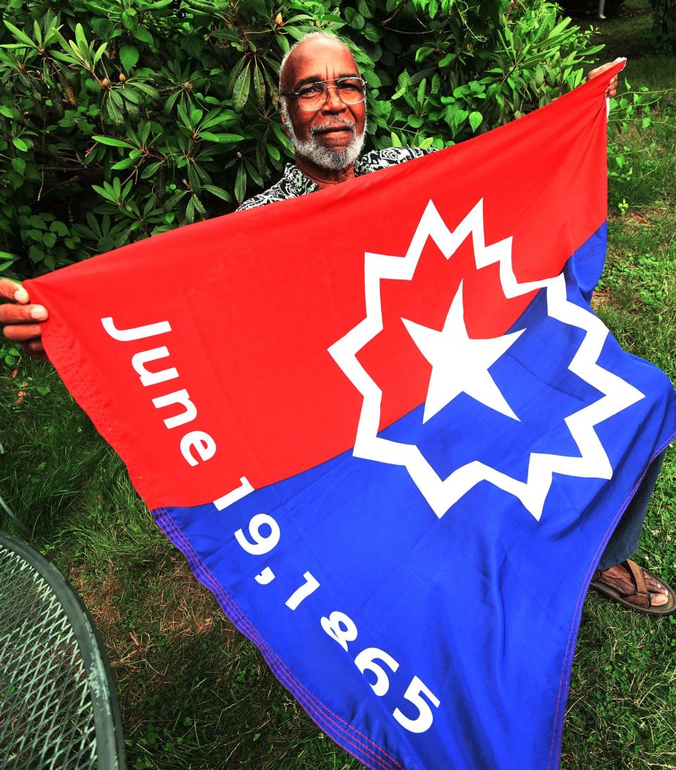 Ben Haith, 79, of Norwich, with the national Juneteenth flag he designed in the mid-1990's.