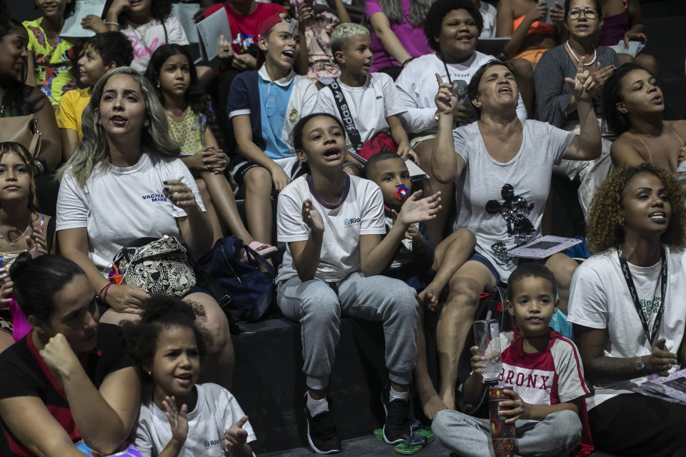 Myrella Victoria Viana dos Santos, 10, center, attends the launch of the book titled “I was supposed to be at school” in the Mare favela of Rio de Janeiro, Brazil, Monday, March 25, 2024. Dozens of kids and teenagers from one of Rio de Janeiro's most violent favelas gathered on Monday to celebrate their most important piece of work yet: a book that aims to show authorities how they see police violence in their Maré community from a young age. (AP Photo/Bruna Prado)