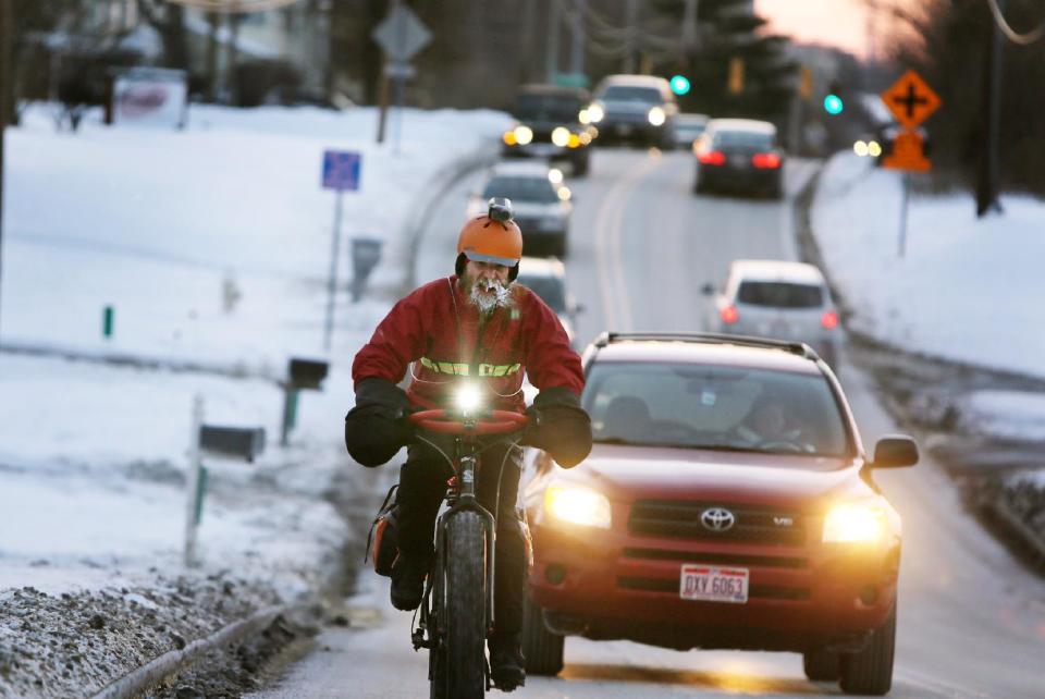 In a Feb. 19, 2014, photo, Fraser Cunningham, 56, of Madeira, Ohio, a General Electric engineer, bicycles home from work in single-digit temperatures. Cunningham hasn't missed a day biking to and from work for a year and a half. The icicles that have formed on his beard are a product of freezing water vapors produced from breathing. (AP Photo/The Cincinnati Enquirer, Carrie Cochran) MANDATORY CREDIT; NO SALES