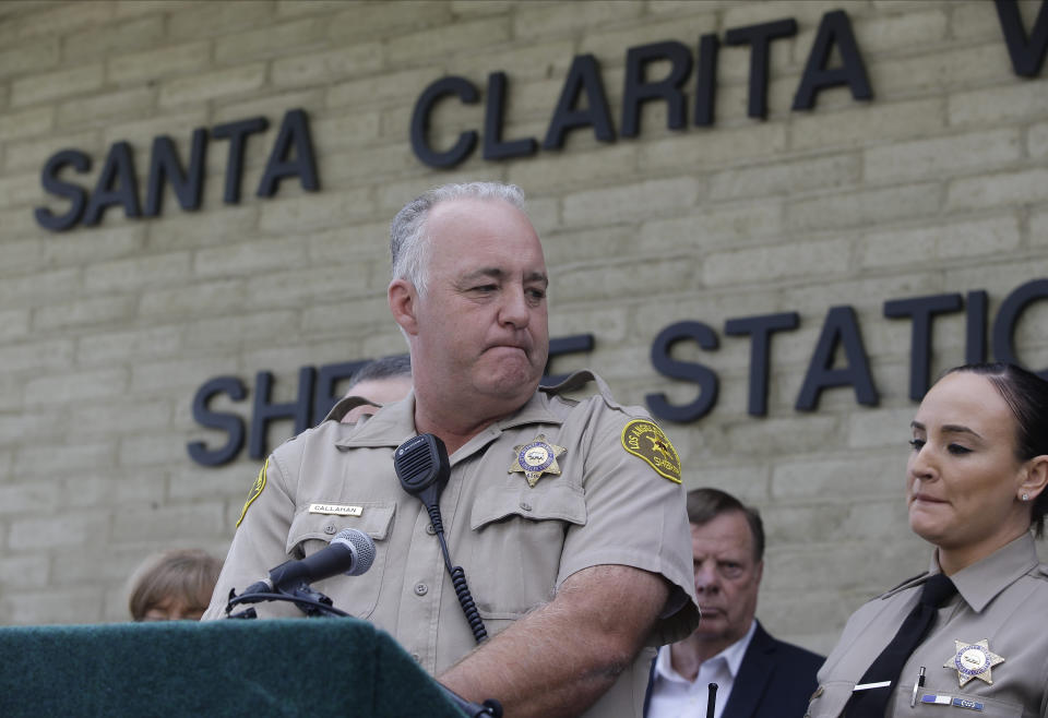 Deputy James Callahan, at podium, takes questions from the media at a news conference at the station Santa Clarita, Calif., Friday, Nov. 15, 2019. Callahan works as a school resource officer at Saugus High School, was on the scene in the aftermath of the shooting, (AP Photo/Damian Dovarganes)