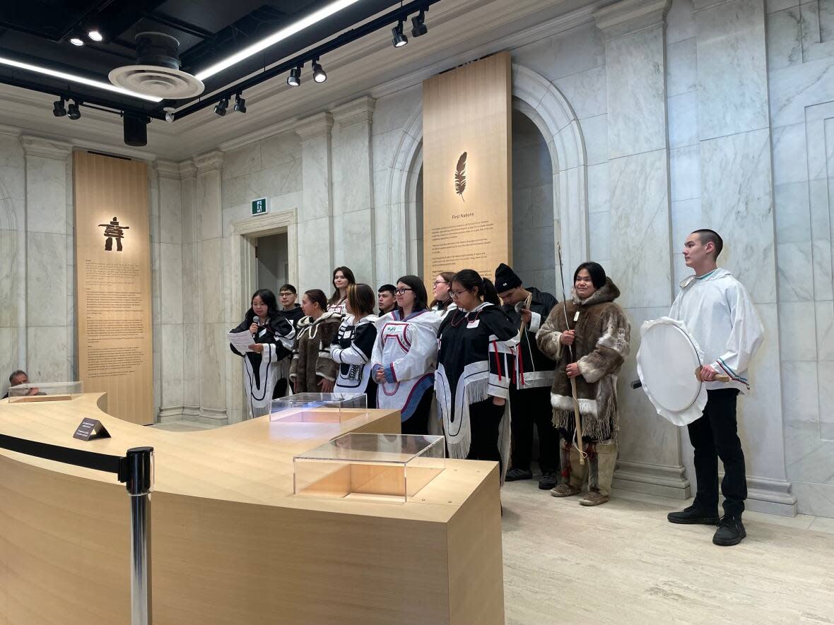 Inuit youth from Nunavut Sivuniksavut (NS) perform a song for the crowd gathered in the foyer of 100 Wellington St. Saturday, a one-day showcase of the long-closed building as part of Ottawa's Winterlude festival. (Avanthika Anand/CBC  - image credit)