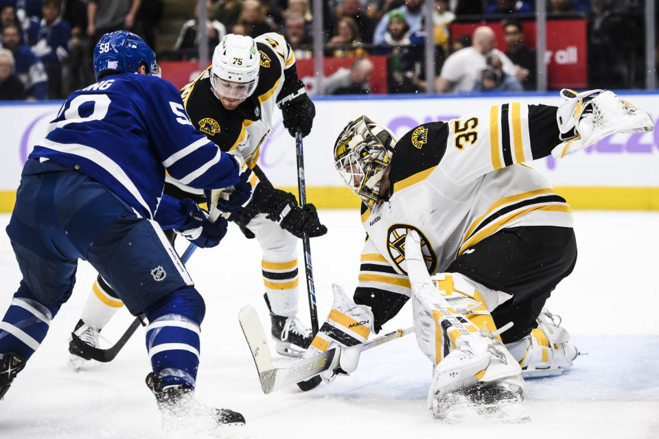 Toronto Maple Leafs forward Michael Bunting (58) and Boston Bruins defenseman Connor Clifton (75) jostle for position while Boston Bruins goaltender Linus Ullmark (35) defends the net during the second period of an NHL hockey game, Saturday, Nov. 5, 2022 in Toronto. (Christopher Katsarov/The Canadian Press via AP)