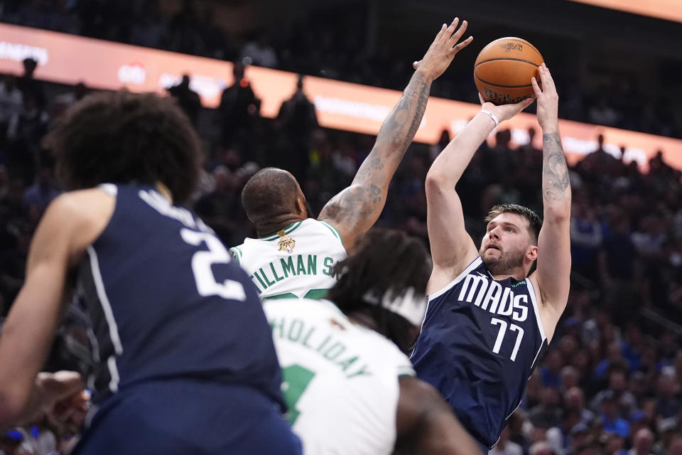 Dallas Mavericks guard Luka Doncic (77) shoots over Boston Celtics forward Xavier Tillman, center, during the first half in Game 4 of the NBA basketball finals, Friday, June 14, 2024, in Dallas. (AP Photo/Julio Cortez)