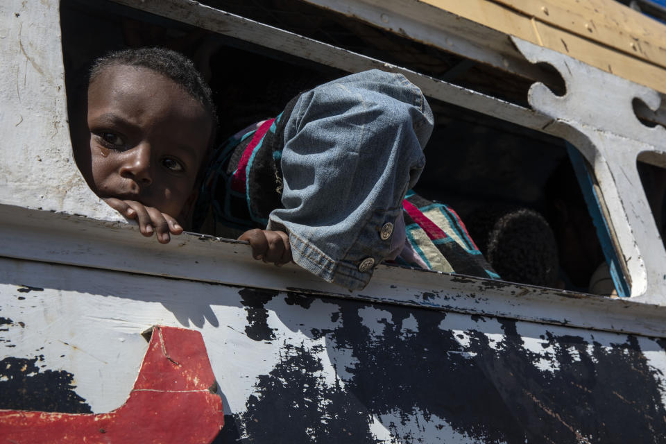 Tigray refugees who fled the conflict in the Ethiopia's Tigray ride a bus going to the Village 8 temporary shelter, near the Sudan-Ethiopia border, in Hamdayet, eastern Sudan, Tuesday, Dec. 1, 2020. (AP Photo/Nariman El-Mofty)