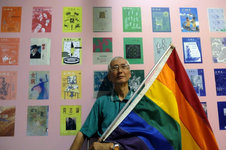 This picture taken on May 19, 2017 shows Taiwanese gay rights campaigner Chi Chia-wei, 59, posing for a photograph with a flag during an exhibition in Taipei