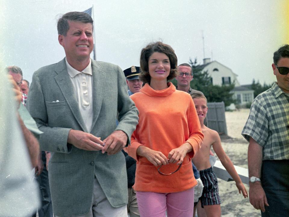 John F. Kennedy and Jacqueline Kennedy. Jacqueline wears an orange shirt and pink pants.