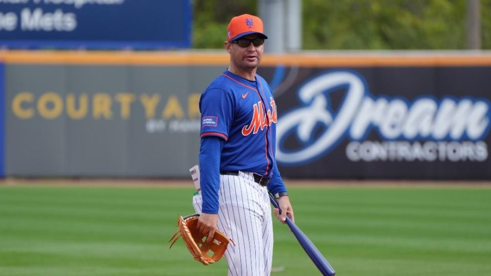New York Mets manager Carlos Mendoza changes stations during workouts at spring training.