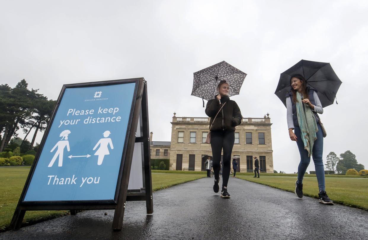 Staff at English Heritage organization carry out a visitor practice dry run with family members at Brodsworth Hall near York, England on June 12, 2020, ahead of the garden's official reopening on Saturday. The restored Victorian gardens are among the very first of English Heritage's staffed properties to reopen, with social distancing measures in place.