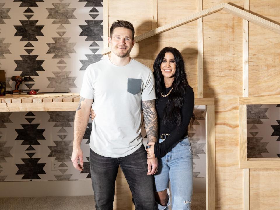 Chelsea and Cole DeBoer pose in front of a playhouse that's being constructed.