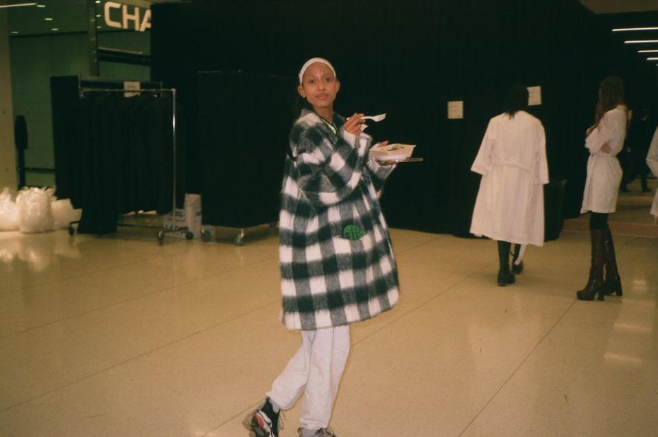 Aighewi quickly eats in between runway walkthroughs and rehearsals.