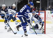 Toronto Maple Leafs right wing William Nylander (88) tries to screen Winnipeg Jets goaltender Connor Hellebuyck (37) during third-period NHL hockey game action in Toronto, Ontario, Monday, Jan. 18, 2021. (Nathan Denette/The Canadian Press via AP