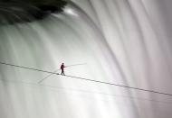 Nik Wallenda walks over Niagara Falls on a tightrope in Niagara Falls, Ontario, on Friday, June 15, 2012. Wallenda has finished his attempt to become the first person to walk on a tightrope 1,800 feet across the mist-fogged brink of roaring Niagara Falls. The seventh-generation member of the famed Flying Wallendas had long dreamed of pulling off the stunt, never before attempted. (AP Photo/The Canadian Press, Frank Gunn)