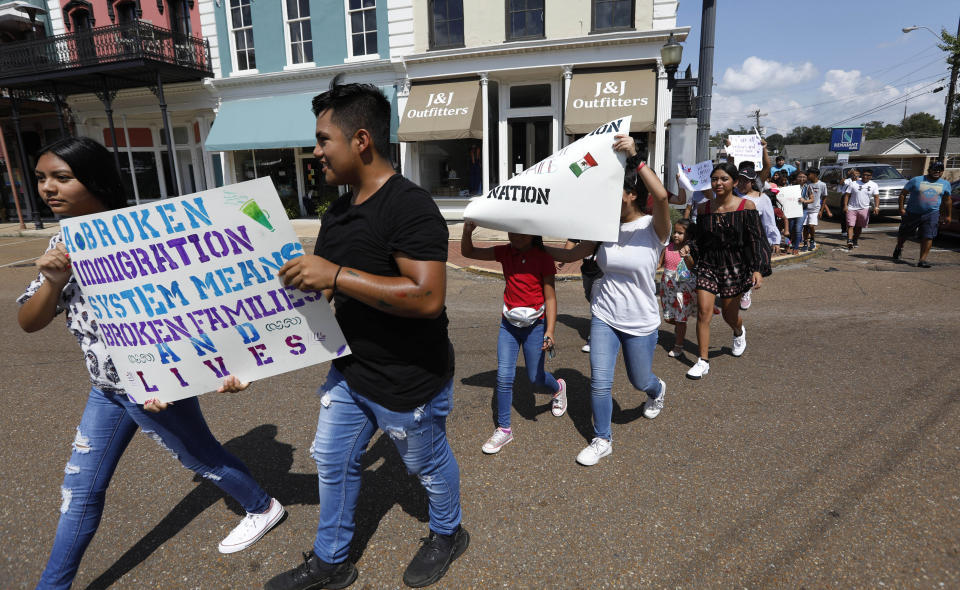 CORRECTS TO SAY THE RAIDS WERE WEDNESDAY, NOT TUESDAY - Children of mainly Latino immigrant parents hold signs in support of them and those individuals picked up during an immigration raid at a food processing plant in Canton, Miss., following a Spanish Mass at Sacred Heart Catholic Church in Canton, Miss., Sunday, Aug. 11, 2019. The raids Wednesday at poultry plants in Mississippi have spurred churches that have been key to providing spiritual and emotional comfort to workers to now step up to provide material aid to jailed or out-of-work church members. (AP Photo/Rogelio V. Solis)