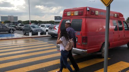 A man with a bandage on his head walks past an ambulance outside the Durango Airport after an Aeromexico-operated Embraer passenger jet crashed right after takeoff in Mexico's state of Durango, July 31, 2018, in this picture obtained from social media. Contacto Hoy/via REUTERS