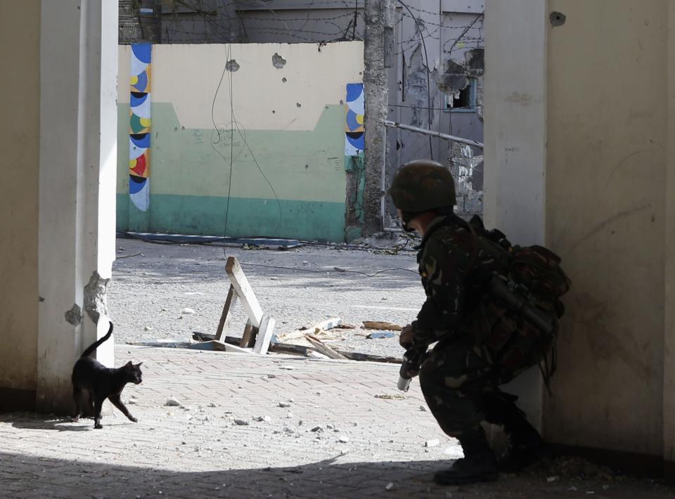 A government soldier of Task Force Zamboanga (TFZ) takes cover during fighting with Muslim rebels of Moro National Liberation Front (MNLF) in Zamboanga city in southern Philippines September 16, 2013. (REUTERS/Erik De Castro)