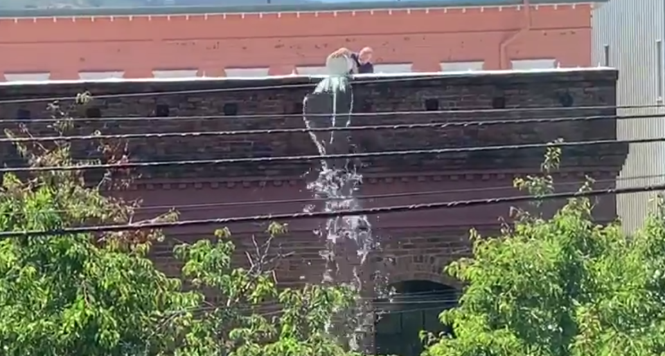 Ein Unbekannter schüttet einen Eimer Wasser auf eine obdachlose Frau. Foto: Screenshot / Twitter / Jim V.o.R.