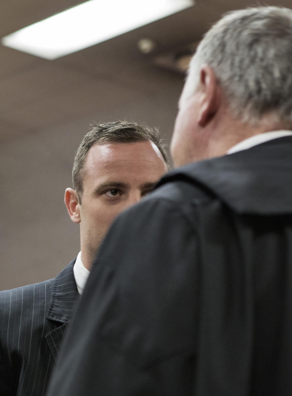 Oscar Pistorius, talks with his defense attorney, Barry Roux, right, in court in Pretoria, South Africa, Tuesday, March 18, 2014. Pistorius is on trial for the murder of his girlfriend Reeva Steenkamp on Valentines Day, 2013. (AP Photo/Marco Longari, Pool)