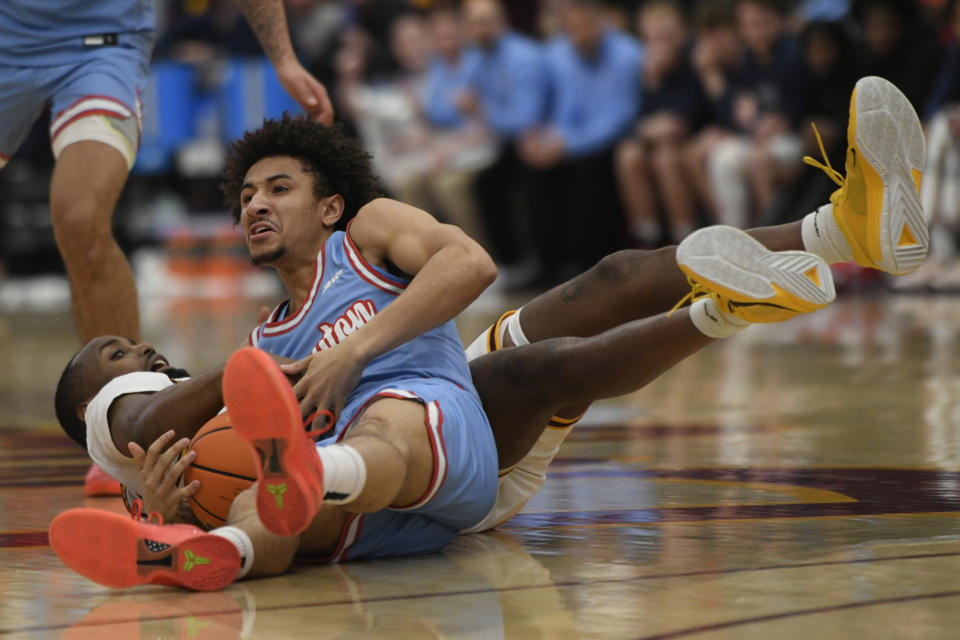 Dayton's Javon Bennett, top, battles Loyola of Chicago's Dame Adelekun, bottom, for the ball during the first half of an NCAA college basketball game Friday, March 1, 2024, in Chicago. (AP Photo/Paul Beaty)