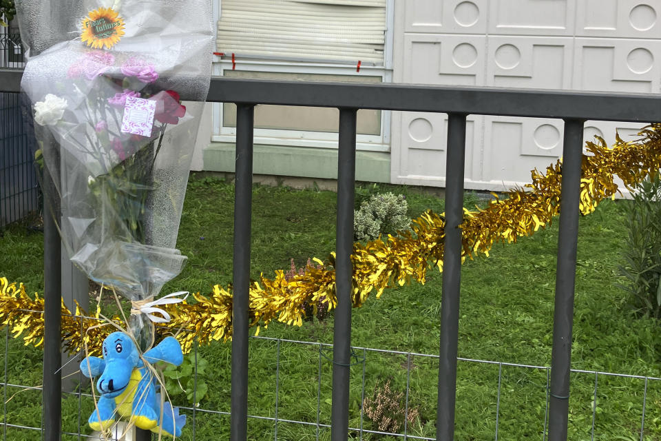 Flowers lay at the building gate where four children between nine months and 10 years old and their mother were found killed, Tuesday, Dec.26, 2023 in Meaux, east of Paris. A woman and her four children, between nine months and 10 years old, were killed in their apartment east of Paris in what the local prosecutor called an exceptionally violent crime. Authorities said the children's father was arrested Tuesday and is the primary suspect. (AP Photo/Nicolas Garriga)