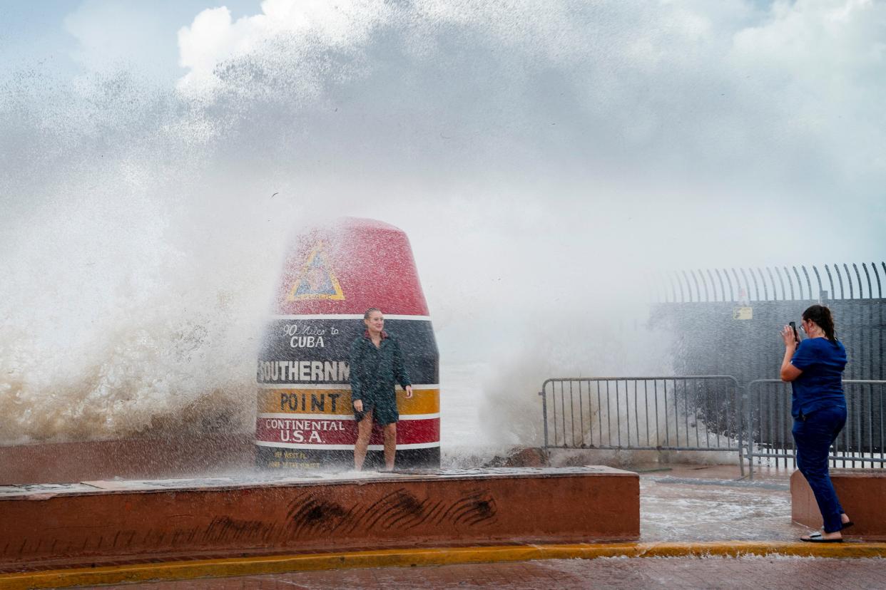 Visitors to the Southernmost Point buoy brave the waves for a few cell phone photos as Hurricane Idalia passes the Florida Keys some 175 miles to the west, on Tuesday, Aug. 29, 2023 in Key West, Fla. Much of Florida was in disaster mode on Tuesday with only hours to go before an onslaught from Idalia, forecast to strengthen rapidly into “an extremely dangerous major hurricane” before hitting the Gulf Coast on Wednesday.