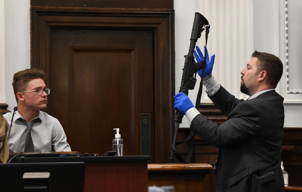 Dominick Black, who bought Kyle Rittenhouse's AR-15-style rifle for him because Rittenhouse was underage, is shown the rifle during his friend's trial on Tuesday at the Kenosha County Courthouse.