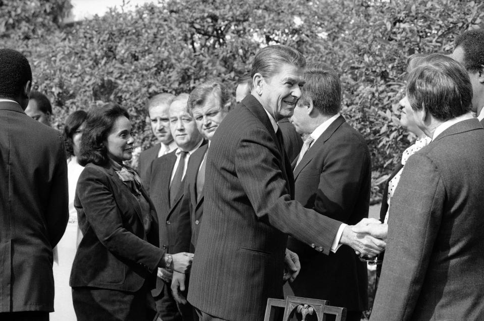 FILE - In this Nov. 2, 1983 file photo President Ronald Reagan, followed by Coretta Scott King, shakes hands with those in attendance to witness the signing of the bill making Martin Luther King, Jr.'s birthday a national holiday, in the Rose Garden. From left: King; Rep. Joe Biden, D-Del.; Sen. Charles McC. Mathias, R-Md.; Sen. Edward M. Kennedy, D-Mass.; Sen. Bob Dole, R-Kan.; Reagan; and Rep. Katie Hall, D-Ind. (AP Photo/Barry Thumma, File)