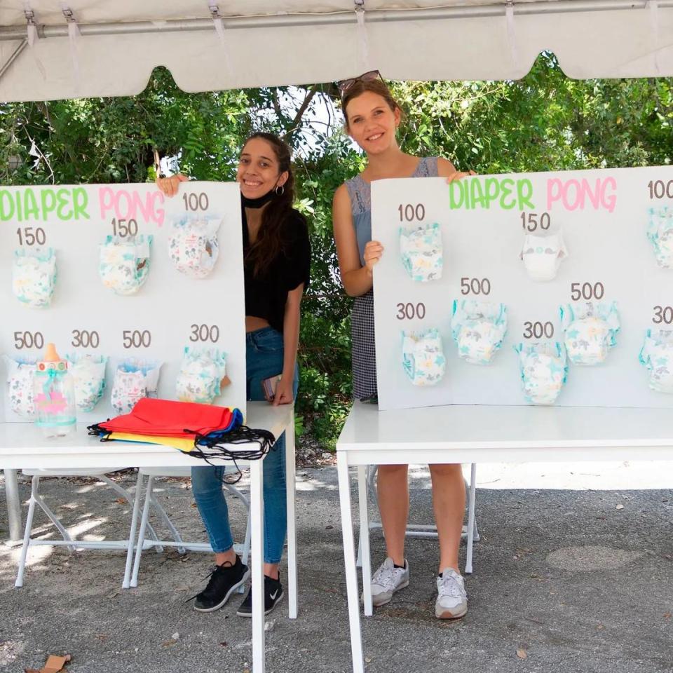 Dos voluntarias de Tree of Life Parentig Center, organización sin fines de lucro, ayudan en la logística del juego “Diaper Pong” durante Baby Shower Comunitario realizado en la ciudad de Coral Gables en 2021