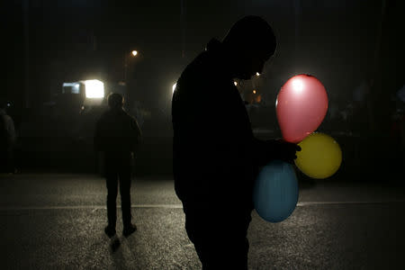 FILE PHOTO: A man holds balloons in the colors of the Romanian flag in Bucharest, Romania, February 5, 2017. Inquam Photos/Octav Ganea/via REUTERS