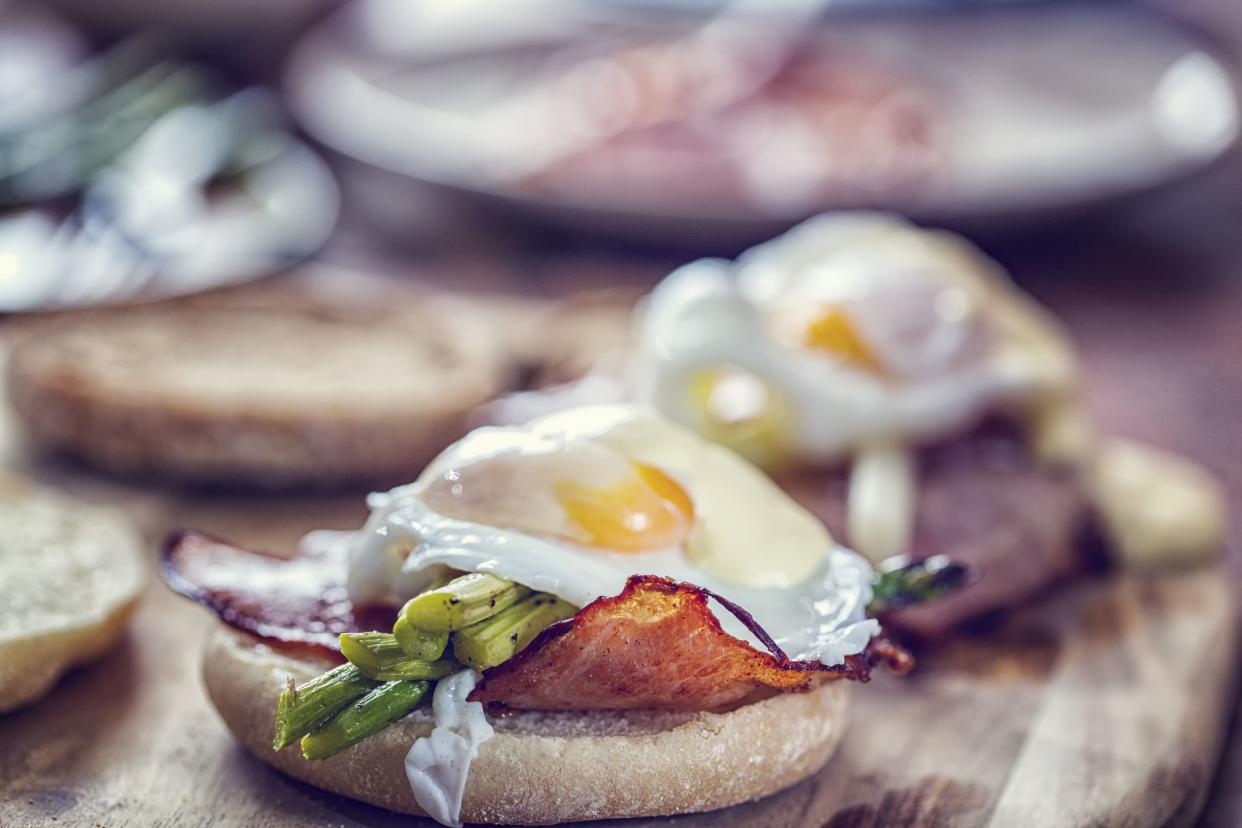 Delicious Egg Benedict with roasted ham, green asparagus, poached egg and sauce hollandaise.