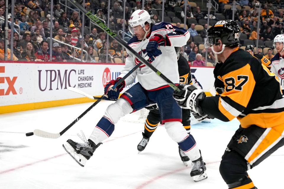 Columbus Blue Jackets' Erik Gudbranson (44) attempts to get off a pass while defended by Pittsburgh Penguins' Lars Eller, rear, and Sidney Crosby (87) during the second period of an NHL hockey game in Pittsburgh, Tuesday, March 5, 2024. (AP Photo/Gene J. Puskar)